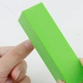 Green 120 grit sponge nail buffer block sanding the edge of a fingernail professionally - Green