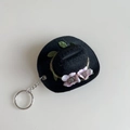 Detail of a mini black cowboy hat keychain with pink flowers and silver metal ring - Black Hat + Pink Flower