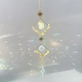 Crystal suncatcher with raw citrine stones and prisms casting rainbow light on white background - Citrine / Yellow