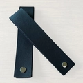 Two black PU leather tags with lychee texture and silver snap buttons on wood background - Folded Size 15x3cm / Black