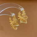 Dettaglio di orecchini a spirale dorati con design geometrico in filo metallico ritorto - Oro
