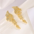 Elegantes pendientes de hoja dorada con circonita AAA en una vista de bodegón profesional - Oro Real