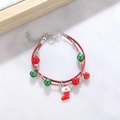 Detail of red and green braided Christmas bracelet with silver bell and festive sock charm - Style N Dainty Xmas Sock