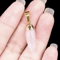 Pink quartz bullet pendant with gold-plated cap held by hand showing real size - Rose Quartz