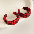 Macro detail of red and black leopard print leather wrapped C-shape hoop earrings - Red