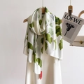 Long silk scarf with green ginkgo leaf print on white background hanging on a hanger - Leaf / 180*90