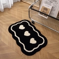 Absorbent black bathroom rug with white heart patterns and wavy edges on wooden floor - 40x60cm / Heart-Black