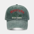 Close-up of embroidered Montana mountain peak logo on washed vintage green baseball cap - Green