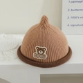 Detail der Baby-Strickmütze mit Bärenstickerei und Rollrand auf minimalistischem Stand - Bär Patch - Khaki