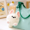 Llavero de perro de peluche blanco con patas rosas colgado de un bolso azul de lona - West Highland Terrier