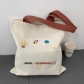Detail of off-white canvas tote bag with red-brown straps and motivational cartoon print - Why Study