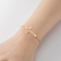 Elegant minimalist cross bracelet in gold finish with thin chain worn on wrist - 339-Cross / Steel