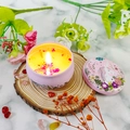 Candela profumata rosa in latta unicorno con petali di fiori che brucia su marmo - Mon Paris
