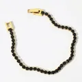 Elegant gold-plated tennis bracelet featuring round black cubic zirconia stones - Gold + Black Zirconia