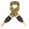 Close-up of leopard print bag strap with brown leather ends and gold metal hardware - Yellow Black Spots