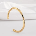Vista detallada de un brazalete de puño en C de oro pulido con acabado de espejo liso - Diámetro Interior 6,8 cm / Dorado