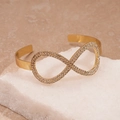 Macro-opname van gouden infinity armband met fonkelende details van zirkonia - Goud