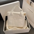 Mini white canvas tote bag with adjustable shoulder strap and front pocket detail - White