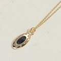Elegant gold necklace with oval black zircon pendant and white stone accents - Black