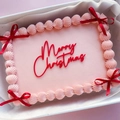 Top view of pink cream cake with red bows and Merry Christmas acrylic topper - Christmas Large Red