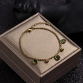 Bracelet à perles dorées avec charmes en zircon vert rond et pendentifs sphères polies - Or - Zircone vert
