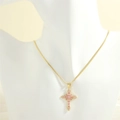 Detail of pink zirconia cross pendant on gold snake chain worn on a white mannequin - Gold Snake Chain / Pink Zircon