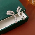Makroansicht der silbernen Schlangenohrringe mit grünen Edelsteinaugen in einer Box - Silber (Silberstift) / Silber