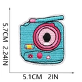 Detailansicht eines Retro-Kamera-Stickaufnähers in Blau und Rosa mit Größenangaben - Kamera