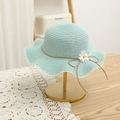 Dettaglio di cappello di paglia verde menta con margherita e bordo in pizzo su supporto - 54cm / Cappello / Blu