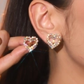 Sparkling gold heart stud earrings with multi-color rhinestones shown in human ear piercing - Gold AB Color Heart Studs (DTE1216036GL-WAB)
