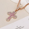 Close-up of rose gold cross pendant with pink square zircon and white diamonds - Cross / Gold Chain with Pink Pendant