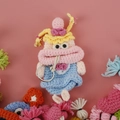 Handmade crochet sausage mouth key holder featuring yellow pigtails and a blue dress - Girl in Blue Dress
