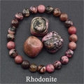 Elastic beaded rhodonite bracelet with natural pink and black stone chunks on dark background - Rhodonite