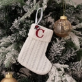 White knitted Christmas stocking with red letter C embroidery hanging on a tree - Embroidered Knitted Small Sock White C