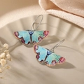 Blue acrylic butterfly drop earrings with purple wing patterns on a ceramic plate - Blue Butterfly Earrings (Cyan-Blue Texture)