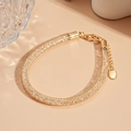Detail of a golden mesh woven bracelet with a lobster clasp and adjustable extender chain - Round Style / Gold / Bracelet