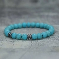 Light blue beaded bracelet with natural texture and dark grey metal spacers on stone surface - 8mm Blue Turquoise