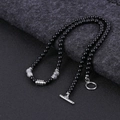 Detail of beaded necklace with tiger eye stones and silver T-bar clasp on dark fabric - Map Stone
