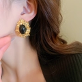 Nahaufnahme von Vintage-Ohrring mit Goldblatt und schwarzem Stein am Modelohr - 32# Silbernadel Schwarzer Achat Unregelmäßiges Goldblatt Ohrringe