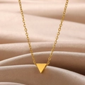 Macro detail of a minimalist gold triangle pendant on a fine chain with satin fabric - Triangle Design