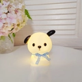 Cartoon dog night light with blue ribbon and warm white glow on a desk - Pipi Dog - Blue