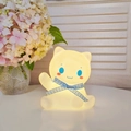 Cute yellow cat night light with a blue checkered ribbon in a warm home setting - Lucky Cat - Blue