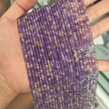 Strand of purple and yellow faceted gemstone beads held in hand for jewelry making - Grade A Dark Ametrine 3mm