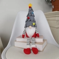 Weihnachtswichtel mit grauem Tannenbaumhut und rotem Körper auf weißen Büchern - Grauer langbeiniger Zwerg