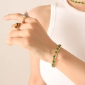 Gold chain jewelry set with green gemstone bracelet and oval stone rings worn by model - Gold Green Zircon Bracelet