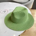 Close-up of grass green woven straw sun hat showing fine Panama style texture and brim detail - Green
