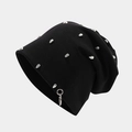 Detail of black knitted beanie featuring silver skull studs and a metal ring pendant - Skull Alien