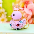 Macro detail of a purple crystal duck keychain with a gold crown and rhinestones - Purple Duck