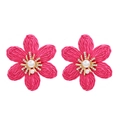 Handmade woven raffia flower earrings with pearls and rhinestones on a white background - Rose Red