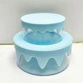 Close-up of a blue cream-style double-layer cake storage box with frosting texture - Blue